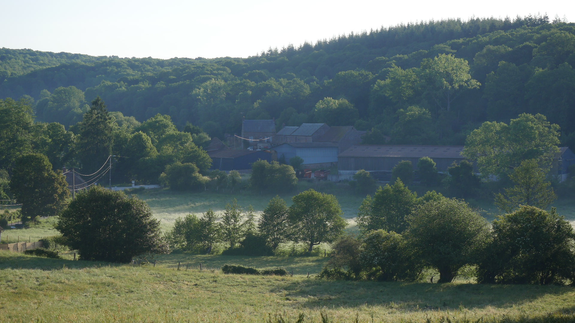 Vue du village de Blacourt depuis les hauteurs, brume matinale sur les prairies